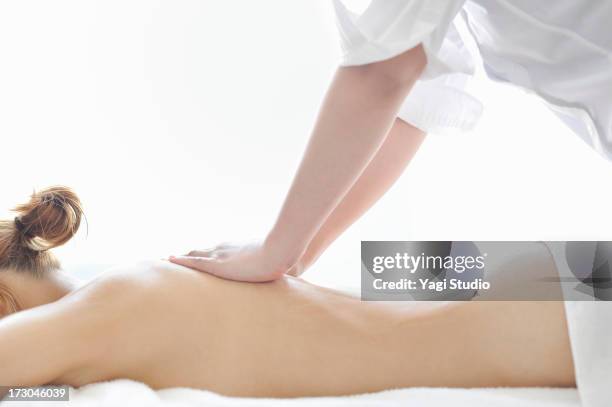 woman receiving oil massage and relaxing - allongé sur le devant photos et images de collection