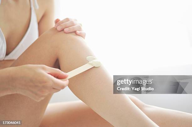 woman doing the brazilian wax hair removal - wachs stock-fotos und bilder