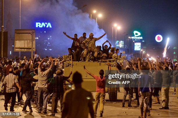 Protesters cheer upon the arrival of the Egyptian Security Forces during clashes between demonstrators for and against ousted president Mohamed Morsi...