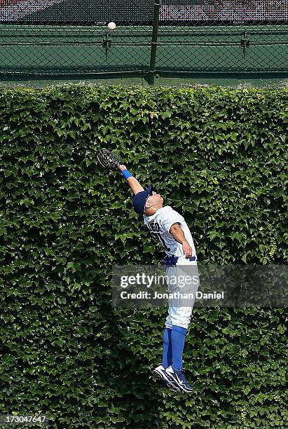 Scott Hairston of the Chicago Cubs leaps in vain for a ball hit by Garrett Jones of the Pittsburgh Pirates in the 5th inning at Wrigley Field on July...