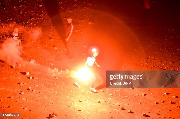 Man holds a flare during clashes between supporters of ousted president Mohamed Morsi and anti Morsi protesters near Egypt's landmark Tahrir square...