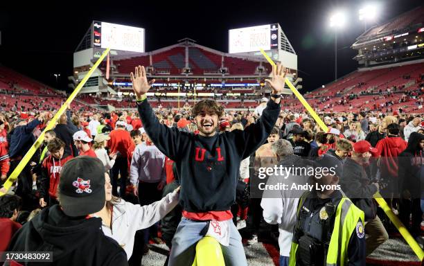 Fans celebrate on the field following the Louisville Cardinals 33-20 win over the Notre Dame Fighting Irish at L&N Stadium on October 07, 2023 in...