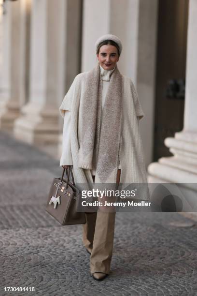 Stefanie Helen is seen wearing a fluffy white headband from Miu Miu, a creme-white long-sleeved pullover with turtleneck from Loro Piana, a...
