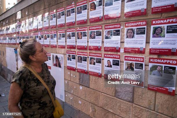 Woman looks at a wall with photos of hostages kidnapped and taken to Gaza in last Saturday's Hamas attack on October 17, 2023 in Tel Aviv, Israel. As...
