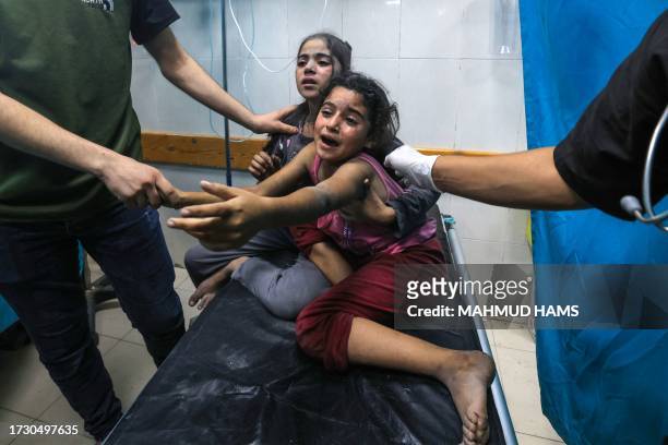 Graphic content / TOPSHOT - Children injured in an Israeli air strike react as they receive treatment in the Nasser hospital in Khan Yunis in the...