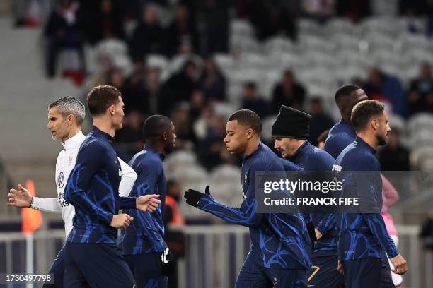 France's forward Kylian Mbappe and France's forward Antoine Griezmann warm up ahead of the friendly football match between France and Scotland at...