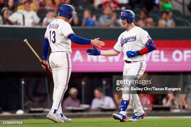 Mitch Garver celebrates with Brad Miller of the Texas Rangers after hitting a home run during a game against the Chicago White Sox at Globe Life...