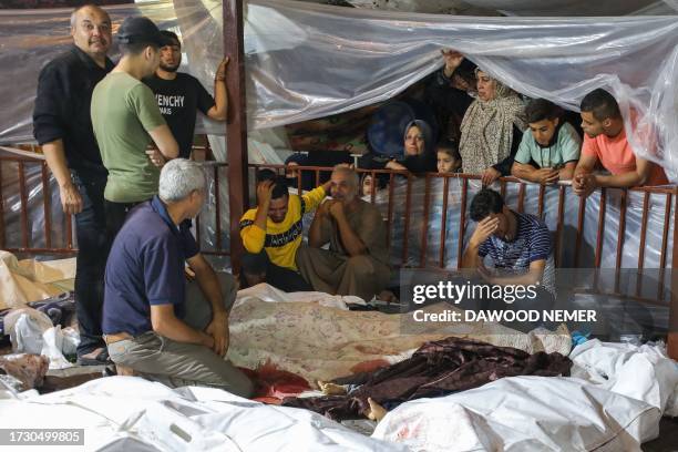 Graphic content / Relatives mourn over the bodies of Palestinians killed after a strike ripped through the Ahli Arab hospital in central Gaza after...