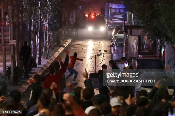 People clash with Palestinian security forces during a rally in solidarity with the Palestinians of the Gaza Strip in the West Bank city of Ramallah,...