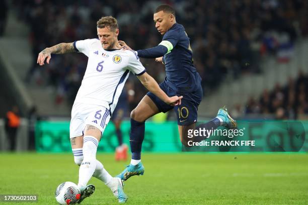 Scotland's defender Liam Cooper fights for the ball with France's forward Kylian Mbappe during the friendly football match between France and...