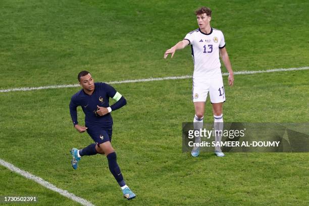 Scotland's defender Jack Hendry gestures next to France's forward Kylian Mbappe during the friendly football match between France and Scotland at...