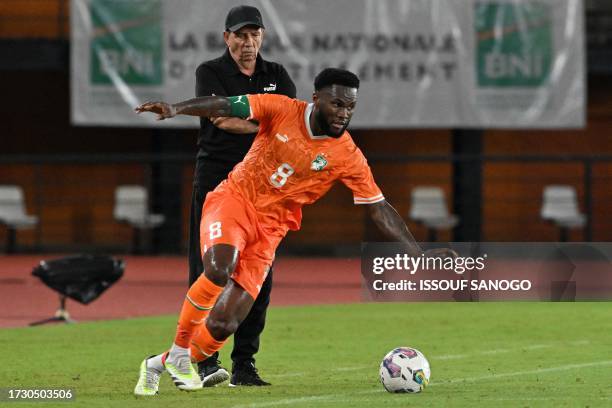 Ivory Coast's French head coach Jean-Louis Gasset looks on from the touchline as Ivory Coast's Franck Kessie prepares to kick the ball during the...