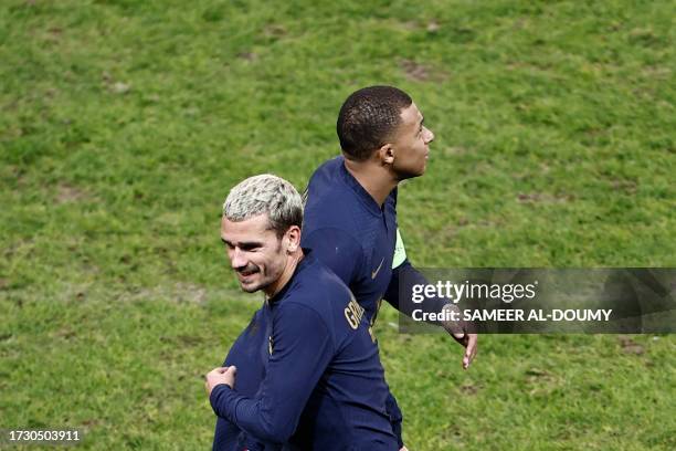 France's forward Antoine Griezmann shakes hands with France's forward Kylian Mbappe as he leaves the pitch during the friendly football match between...