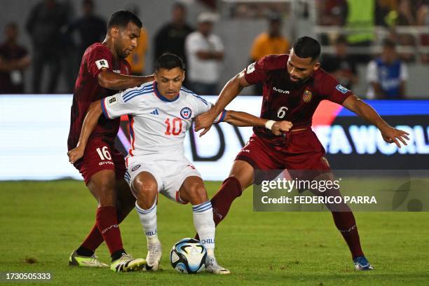 Chile's forward Alexis Sanchez is challenged by Venezuela's midfielders Cristian Casseres Jr and Yangel Herrera during the 2026 FIFA World Cup South...