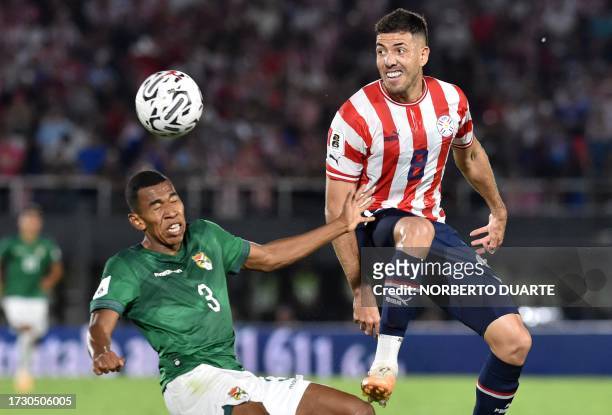 Bolivia's defender Diego Medina and Paraguay's midfielder Alvaro Campuzano fight for the ball during the 2026 FIFA World Cup South American...