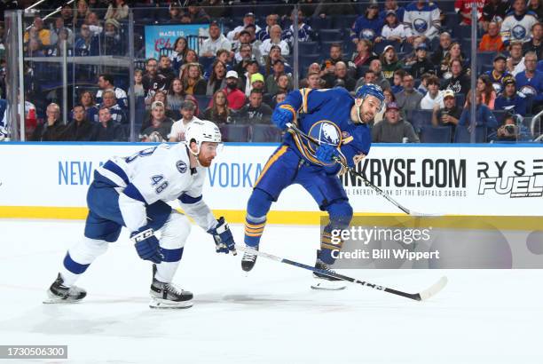 Zemgus Girgensons of the Buffalo Sabres scores a first period goal while defended by Nick Perbix of the Tampa Bay Lightning during an NHL game on...