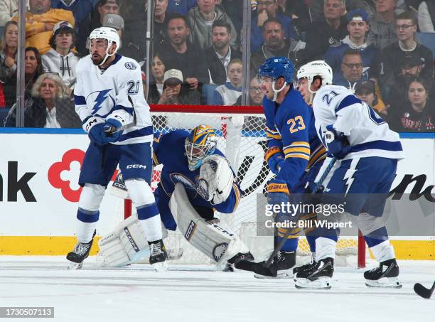 Devon Levi and Mattias Samuelsson of the Buffalo Sabres defend against Nicholas Paul and Brayden Point of the Tampa Bay Lightning during an NHL game...