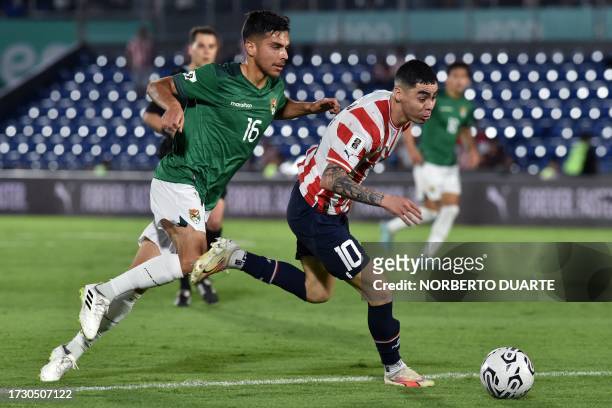 Bolivia's midfielder Boris Cespedes and Paraguay's midfielder Miguel Almiron fight for the ball during the 2026 FIFA World Cup South American...