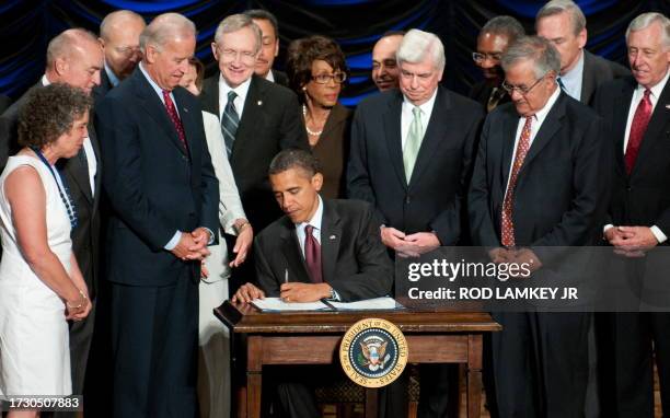 President Barack Obama signs the Dodd-Frank Wall Street Reform and Consumer Protection Act alongside members of Congress, the administration and US...