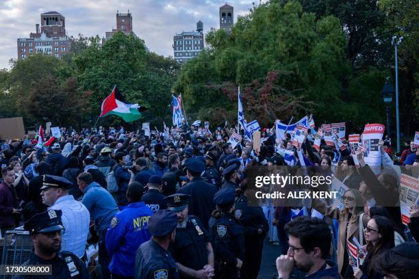 Counter-protestors, who are pro-Israel, chant across a line of police officers towards a vigil organized by NYU students in support of Palestinians...