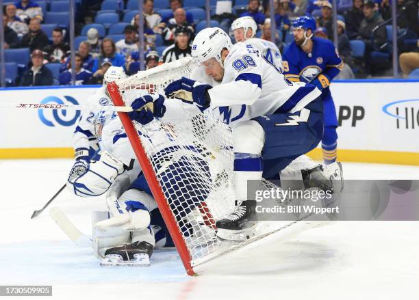 Mikhail Sergachev of the Tampa Bay Lightning crashes into the net behind Jonas Johansson during an NHL game against the Buffalo Sabres on October 17,...