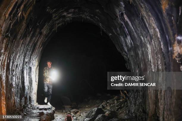 Visitor Mario Garbin flashlights as he walks inside a dark tunnels at the Zeljava underground army airbase in the heart of the Pljesevica mountain,...