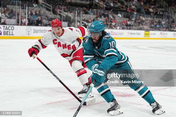 Anthony Duclair of the San Jose Sharks skates with the puck in the first period against Dmitry Orlov of the Carolina Hurricanes at SAP Center on...