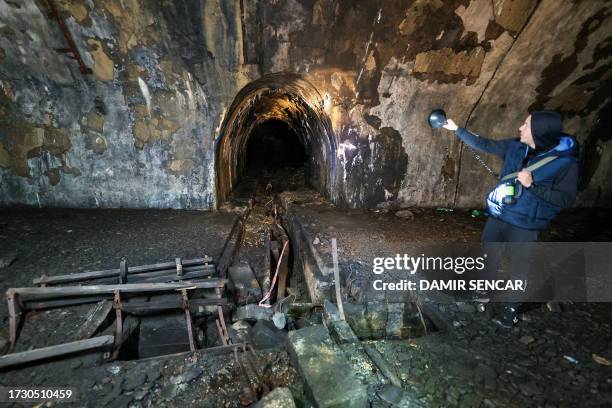 Person flashlights to shows the connecting tunnel and stalactites about 10 centimetres long inside Zeljava underground army airbase in the heart of...