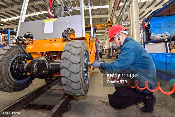 An employee works on a forklift at a factory in Qingzhou, in China's eastern Shandong province on October 18, 2023. / China OUT