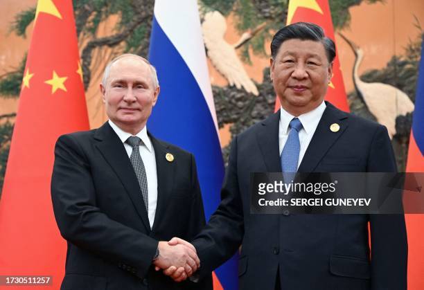 This pool photograph distributed by Russian state owned agency Sputnik shows Russia's President Vladimir Putin and Chinese President Xi Jinping...