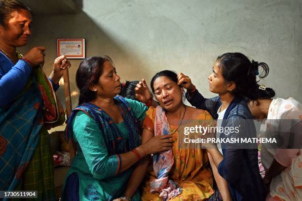 In this photograph taken on October 13 Manju Devi Danguara , the mother of Ashish Chaudhary, is consoled by family members at her residence in the...