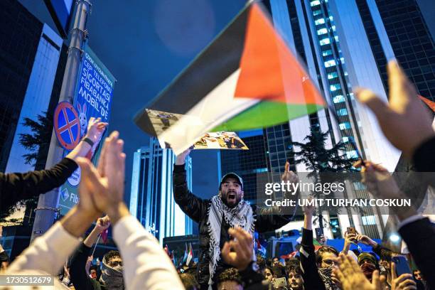Protesters shouts slogans and wave a Palestinian flag during a rally in support of Palestinians in Istanbul on October 18, 2023. Turkish President...
