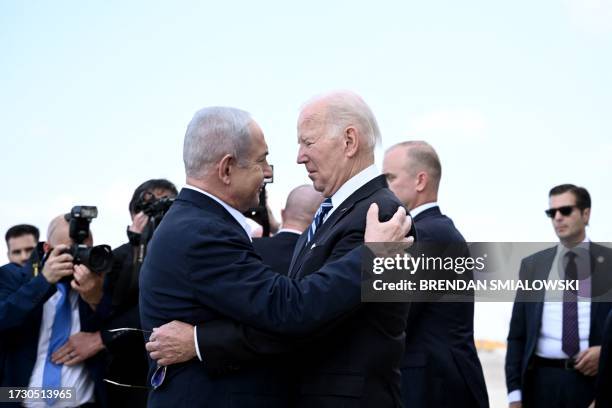 Israel Prime Minister Benjamin Netanyahu greets US President Joe Biden upon his arrival at Tel Aviv's Ben Gurion airport on October 18 amid the...