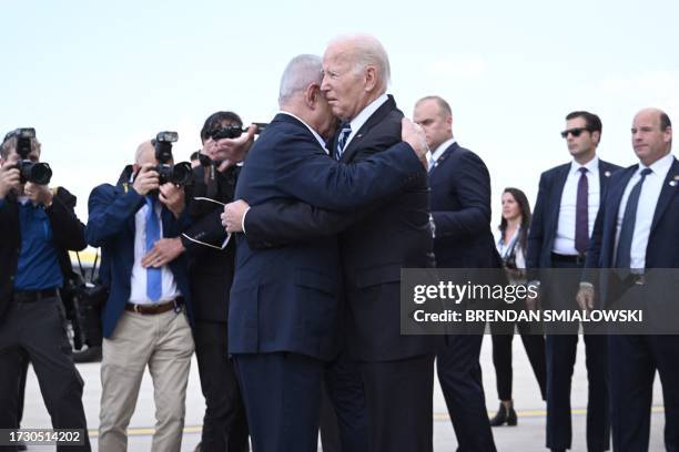 Israel Prime Minister Benjamin Netanyahu hugs US President Joe Biden upon his arrival at Tel Aviv's Ben Gurion airport on October 18 amid the ongoing...