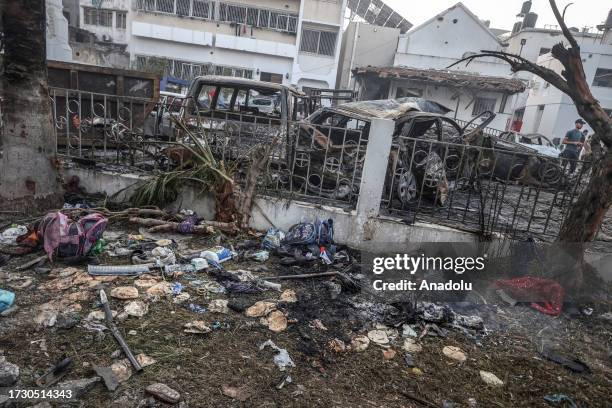 Damaged bags full of clothes belonging to civilians are seen as civilians collect usable belongings amid wreckage of vehicles after Al-Ahli Baptist...