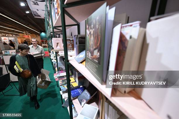 People fill the bookshelves at the booth of Slovenia, 2023 Guest of Honor of the Frankfurt Book Fair, on the first day of the world's biggest book...