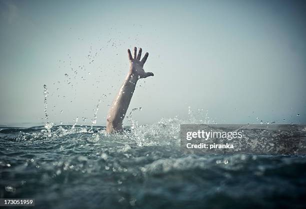 hand emerges splashing water from below - sinking stockfoto's en -beelden