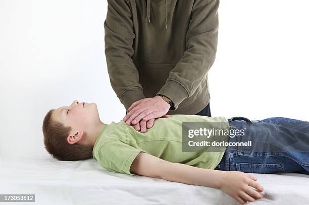 man demonstrating cpr on a young boy - cpr stock pictures, royalty-free photos & images