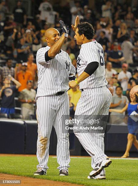 Shortstop Luis Cruz of the New York Yankees celebrates with teammate left fielder Vernon Wells after Wells hit a walk-off game-winning single in the...