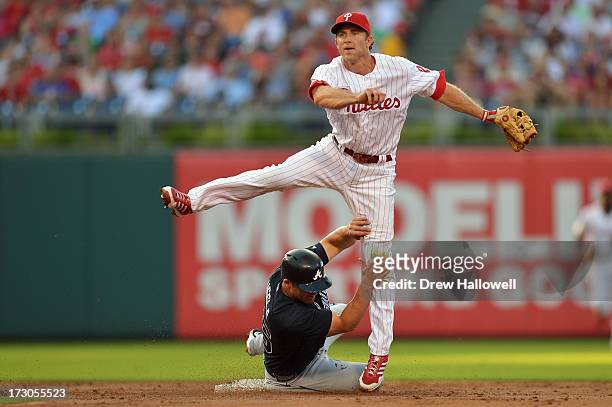 Dan Uggla of the Atlanta Braves slides into Chase Utley of the Philadelphia Phillies on a double play in the second inning at Citizens Bank Park on...