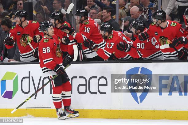 Connor Bedard of the Chicago Blackhawks celebrates with teammates after scoring his first NHL goal during the first period of the Boston Bruins home...