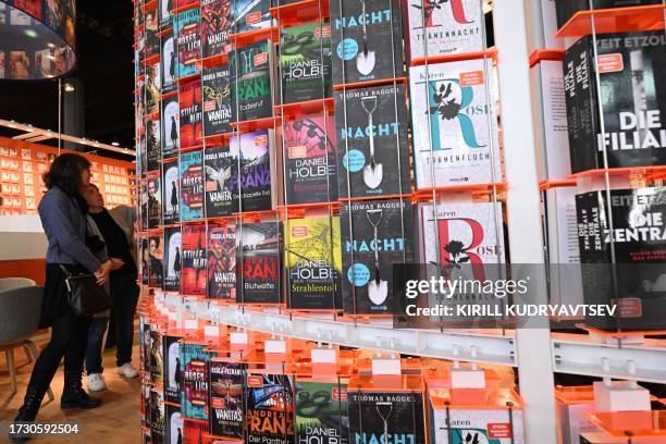 People look at books on display on the first day of the world's biggest book fair, the Frankfurt book fair, on October 18, 2023 in Frankfurt am Main,...