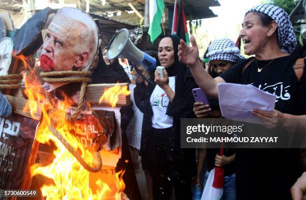 Woman speaks as an image of US President Joe Biden is burnt during a protest in the Ain al-Hilweh Palestinian refugee camp near the southern Lebanese...