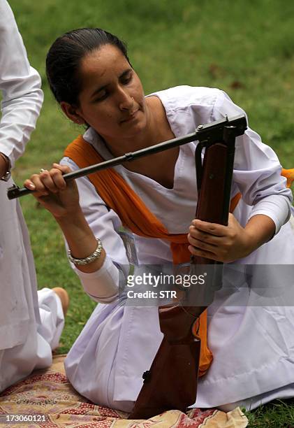 An Indian Hindu girl of the Durga Vahini, the 'saffron brigade' women's wing of the Hindu hardliner organization Vishwa Hindu Parishad , cocks a...