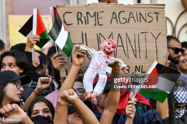 Protesters raise a doll depicting a baby as they chant slogans during an anti-Israel demonstration outside the French embassy headquarters along the...