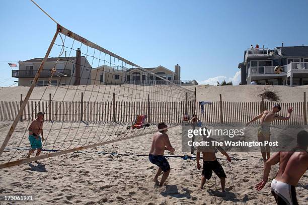 Long Beach Island, NJ Housing are missing in the background as friends play beach volleyball at Beach Haven on Long Beach Island, NJ on June 29,...