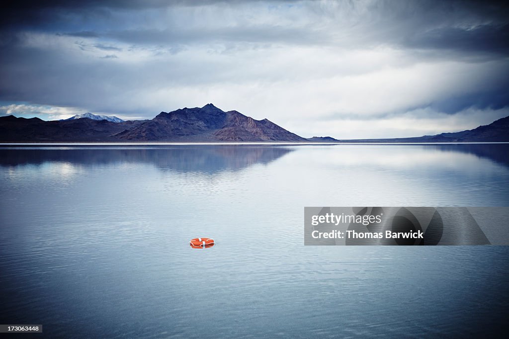 Life ring floating on water under stormy sky