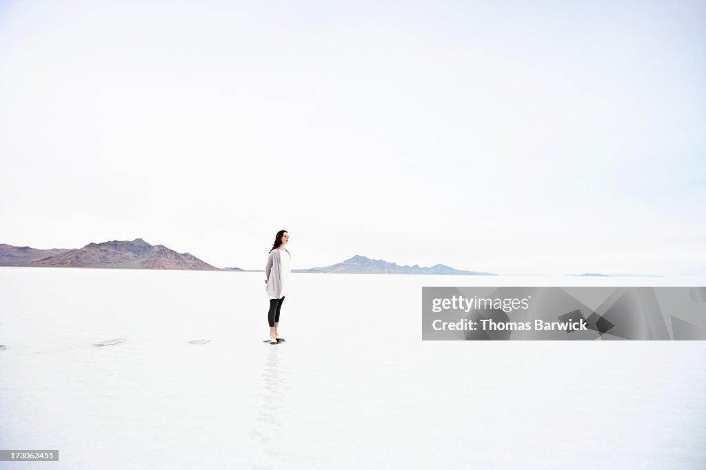 Woman on tip toe at end of stone path in lake