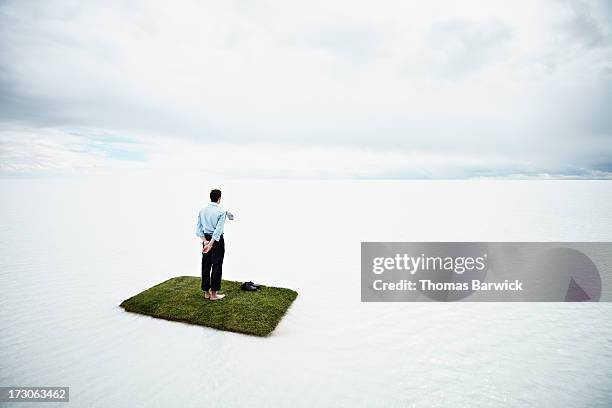 businessman on small island in large body of water - patient journey stock pictures, royalty-free photos & images