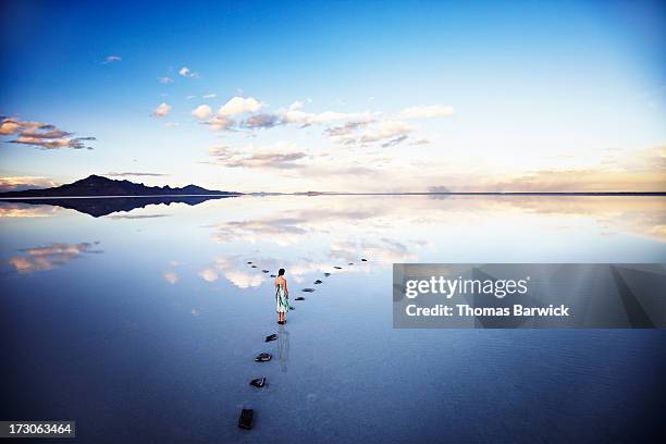 woman at fork in stone pathway in lake at sunset - imperial system fotografías e imágenes de stock